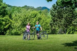 two people standing with bikes in a field at Café im Hof- Bed & Breakfast in Streufdorf