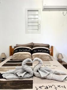 a bedroom with a bed with two towels on it at Lavann Wouj - Proche des plages et du Bourg in Anse-Bertrand