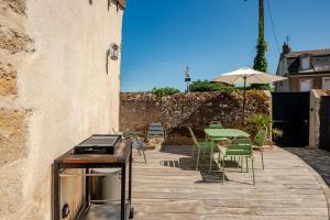 a patio with a table and chairs and an umbrella at Gîte des Chaumottes, meublé avec terrasse in Autun