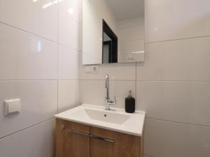 a white bathroom with a sink and a mirror at Scenic Stay with Sauna in Anjum +23 photos