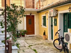 a bike parked in front of a yellow house at Nennella's House in Ágios Rókkos