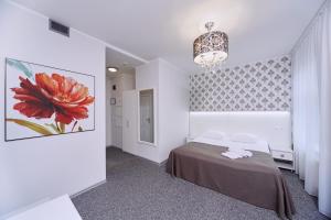 a bedroom with a bed and a painting of a flower at My Hotel OK & Coliving in Riga