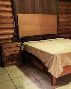 a bed with a wooden headboard in a room at Cabañas Rincon del Ángel 1 in Ciénaga