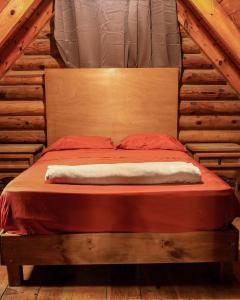 a bed in a room in a log cabin at Cabañas Rincon del Ángel 1 in Ciénaga