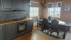 a kitchen with a table and a dining room at Hytte i Myrkdalen in Helgatun