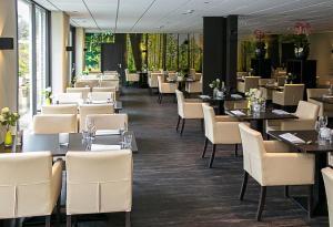 a dining room with tables and white chairs at Fletcher Hotel Restaurant De Eese in De Bult