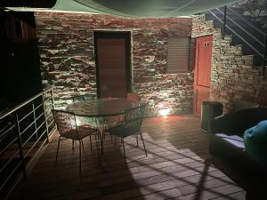 einen Tisch und Stühle in einem Zimmer mit Ziegelwand in der Unterkunft maison de bord de mer cap corse in Santa-Maria-di-Lota + 10 Fotos