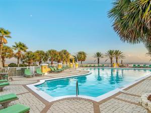 a pool at a resort with palm trees and chairs at 301 West in Gulf Highlands