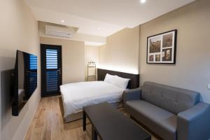 a living room with a bed and a couch at 逢希小宿 in Taichung