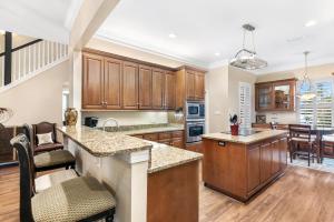 cocina abierta con armarios de madera y comedor en Bonavita, en Gulf Highlands