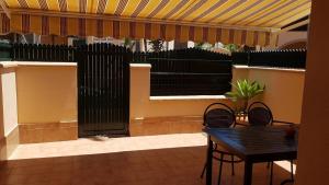 a patio with a table and chairs and a black fence at Al- Andalus in Novo Sancti Petri +5 photos
