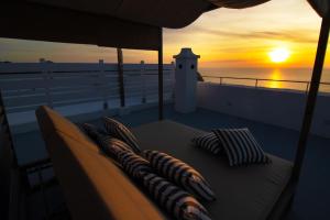 a bed with pillows on a balcony with a sunset at Villa Titina - Sunset Apartments in Ischia +61 photos