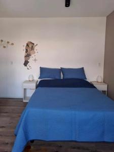 a bedroom with a blue bed with two white tables at Relax en Colegiales in Buenos Aires