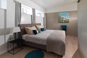 a bedroom with a large bed with blue pillows at Het Raedthuys in Schoondijke