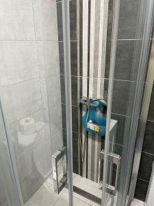a shower stall with a blue blow dryer in it at Stan na Novom Bubnju in Kragujevac +11 photos