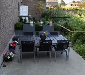 a table with chairs and flowers on a patio at Het Raedthuys in Schoondijke +19 photos