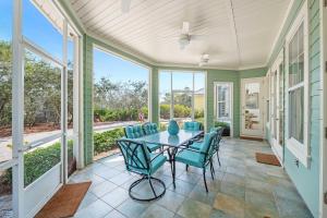 a screened porch with a table and chairs at Blue Bayou in Gulf Highlands