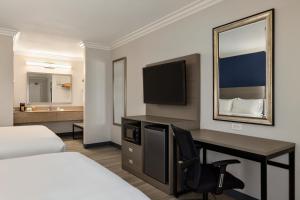 a hotel room with a desk with a bed and a television at Quality Inn Lake Elsinore I-15 in Lake Elsinore