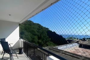 a balcony with a chair and a view at 2 quartos São Conrado ao lado Hotel Nacional in Rio de Janeiro