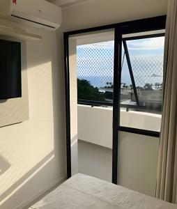 a bedroom with a sliding glass door with a window at 2 quartos São Conrado ao lado Hotel Nacional in Rio de Janeiro +52 photos