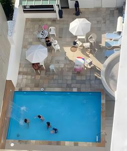 an overhead view of a swimming pool with people and umbrellas at 2 quartos São Conrado ao lado Hotel Nacional in Rio de Janeiro