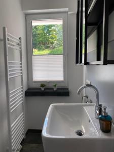 a white sink in a bathroom with a window at #2 Ommi Kese Sansibar Apartment Panorama Balkon in Olpe +33 photos