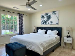 a bedroom with a large bed with a blue ottoman at Two Hilltop Villas with Pool Oasis, Views and Avocado Grove in Fallbrook +36 photos