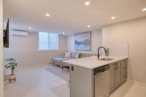 cocina y sala de estar con fregadero y sofá en Stylish & Comfy Mountain Escape King Bed PS5!, en Calgary 27 fotos más