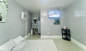 a room with a bed and a tv on the wall at Sleep Zone Hostel in Moalboal