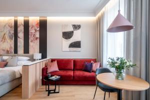 a living room with a red couch and a table at Baltic Haven Sopot in Sopot