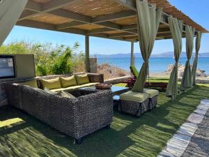a patio with wicker furniture and a view of the ocean at OpenSea Villa in Thermisía