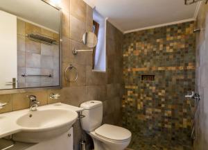 a bathroom with a toilet and a sink and a mirror at OpenSea Villa in Thermisía +24 photos