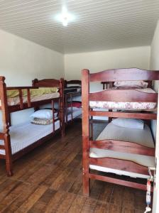 ein Zimmer mit drei Etagenbetten in einem Zimmer in der Unterkunft Recanto da Nicea in Córrego do Bom Jesus