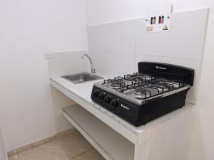 a kitchen counter with a stove and a sink at Casa Bella Vista in Bogotá