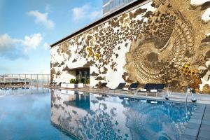 un edificio con una piscina con un mural. en W Hong Kong, en Hong Kong