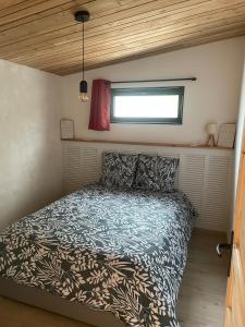 a bedroom with a bed in a tiny house at Ar Kabanenn, la cabane bretonne cosy in Noyal-Muzillac