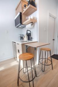 a kitchen with two bar stools and a microwave at Studio #4 - Self Check-In - Plateau - St-Denis in Montréal +19 photos