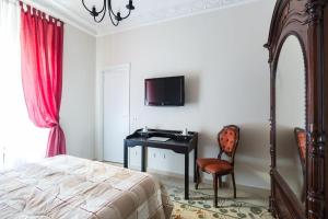 ein Schlafzimmer mit Bett, Schreibtisch und Fernseher in der Unterkunft B&B Calamatta in Rom