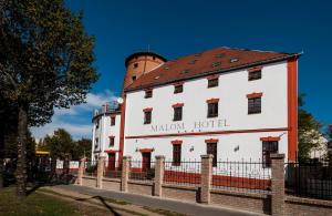a white building with a red roof at Malom Hotel in Debrecen