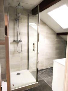 une douche avec une porte vitrée dans une salle de bain dans l'établissement Lac et étoiles, à Savines