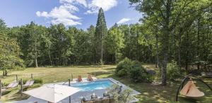 a swimming pool in a yard with trees at Lodge de Loire - B & B proche Chambord in Saint Laurent Nouan