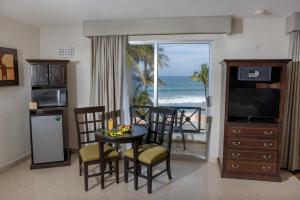 ein Wohnzimmer mit einem Esstisch und Meerblick in der Unterkunft Best Western Hotel Posada Freeman Zona Dorada in Mazatlán