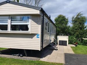 a tiny house is parked in a yard at 3 bedroom Caravan Craigtara in Ayr