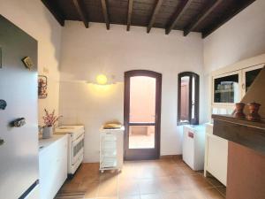 a large kitchen with white counters and a door at Villa Rosa Bestvacationever in Torre delle Stelle +21 photos