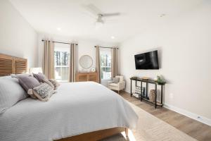 ルイスにあるBrand New Lewes House-Sleeps 14の白いベッドルーム(ベッド1台、薄型テレビ付)