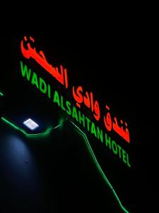 een neonbord voor een wadi malikiiki istg hotel bij فندق وادي السحتن in Al Ambaḩ