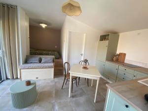 a small kitchen with a table and a bed at Studio 2-3 pers in La Gaubretière