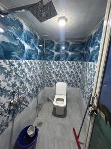 PrayagrajにあるKumbhaLivinggの青と白の壁紙を用いたバスルーム(トイレ付)