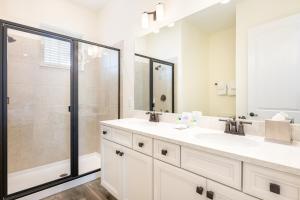 ein weißes Badezimmer mit Dusche und Waschbecken in der Unterkunft Margaritaville Cottages Orlando with H2O Waterpark by Rentyl in Kissimmee