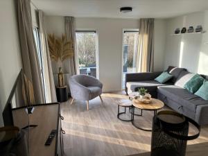 a living room with a couch and a table at Chalet Lutafaro near beach Petten in Petten